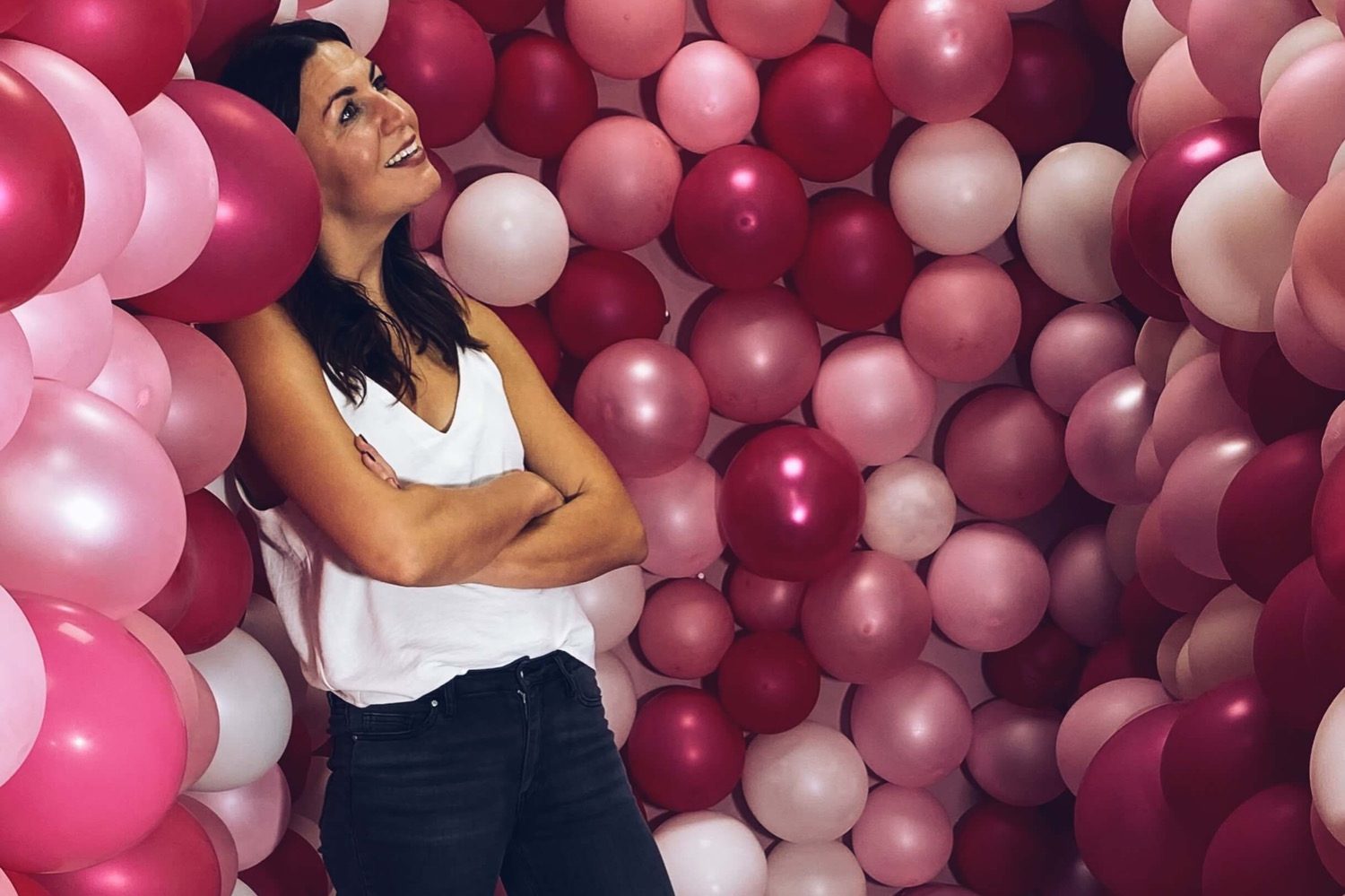 luxem werk - social media Irina Luxem vor einer pink Romanen Luftballon-Wand